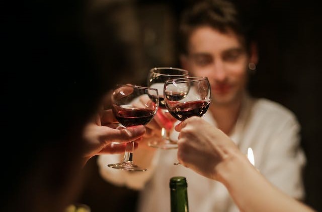 Three friends toasting three glasses of wine together