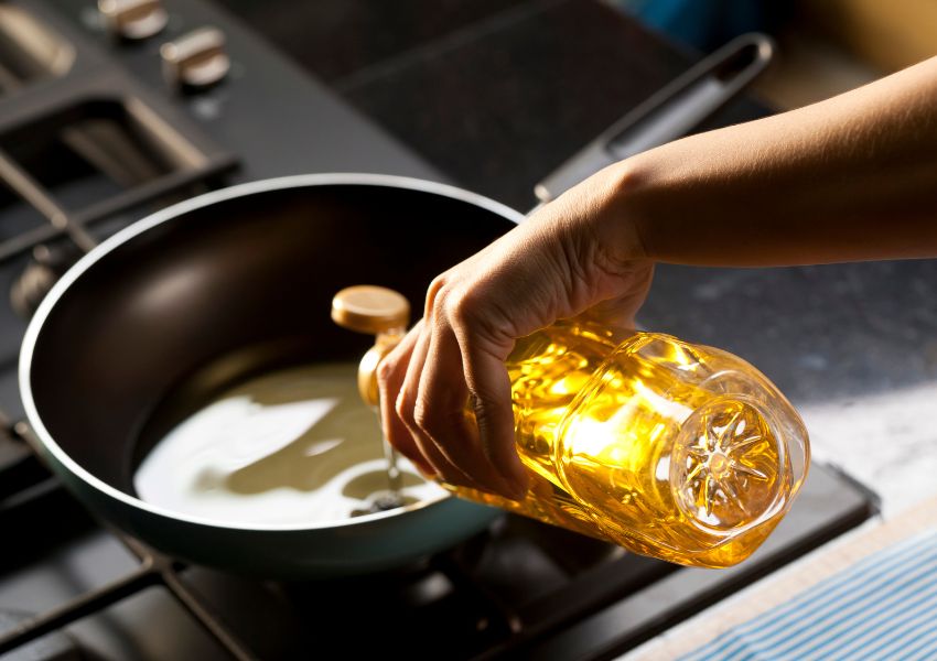 person-pouring-oil-into-pan